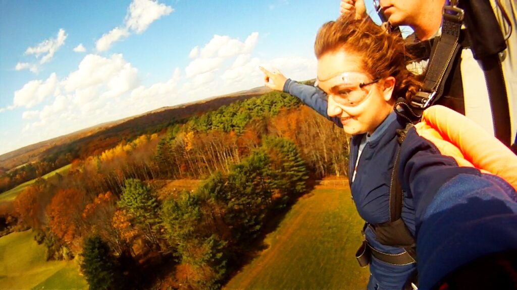 Forest canopy with fall colors + skydiver.