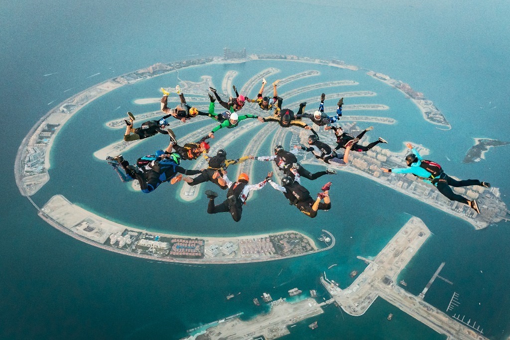 Skydiver above Palm Jumeirah with coastline.