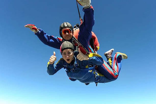 Couple doing tandem skydiving with heart-shaped parachute design