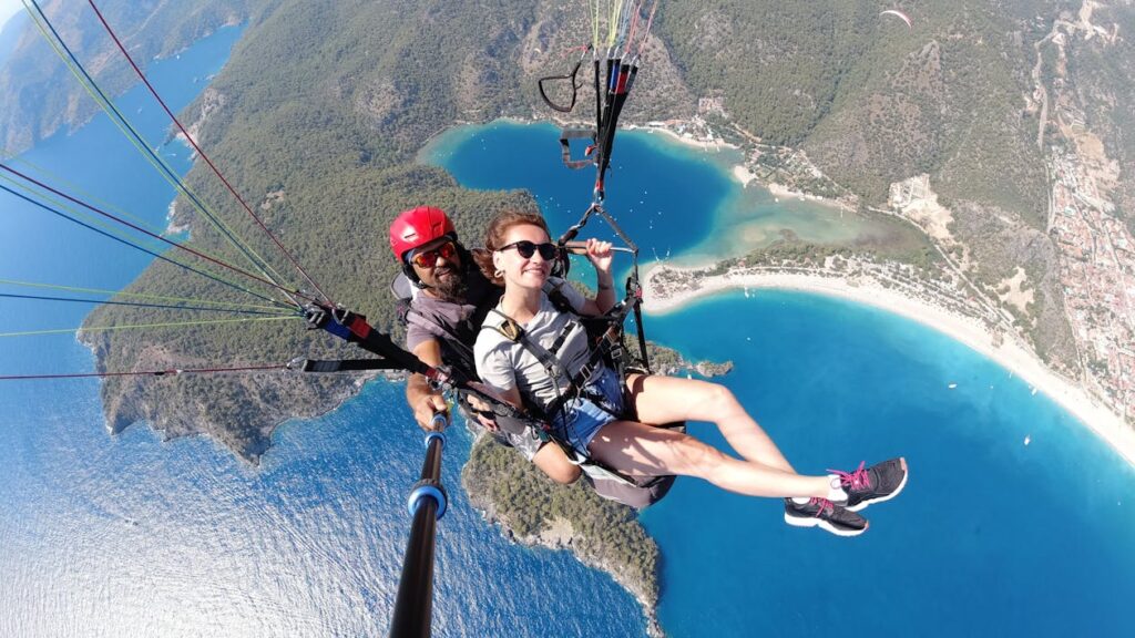 Couple in skydiving gear with northern lights visible in background sky