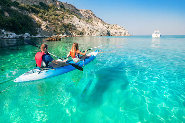 Couple kayaking together on calm turquoise water