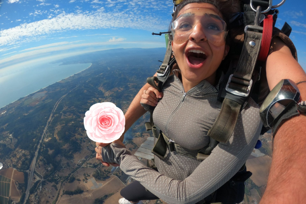 Couple skydiving together holding roses with Valentine's heart overlay