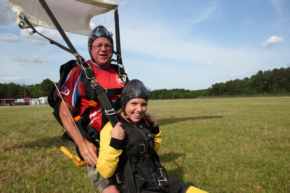 Tandem skydiver landing safely with instructor